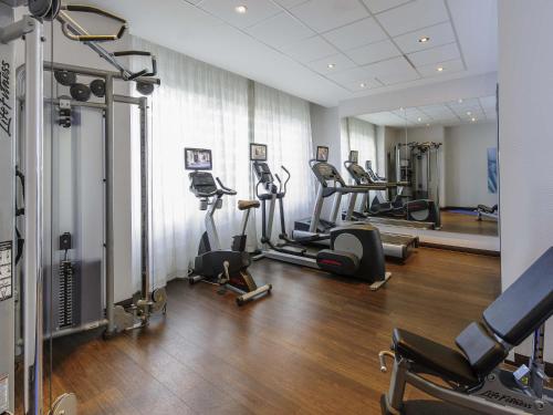 a gym with a bunch of exercise bikes in a room at Mercure Hotel Bochum City in Bochum