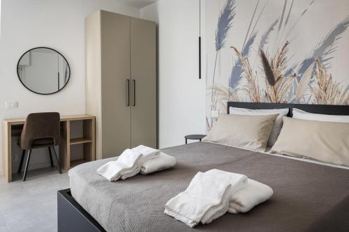 a bedroom with a bed with two towels on it at Antares b&b in Cassina deʼ Pecchi