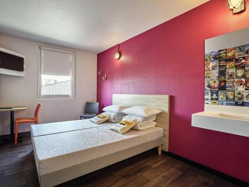 a bedroom with a bed and a red wall at hotelF1 Evreux Sud in Évreux