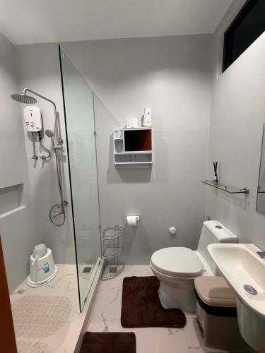 a bathroom with a toilet and a sink and a microwave at Villa Dietze in Davao City