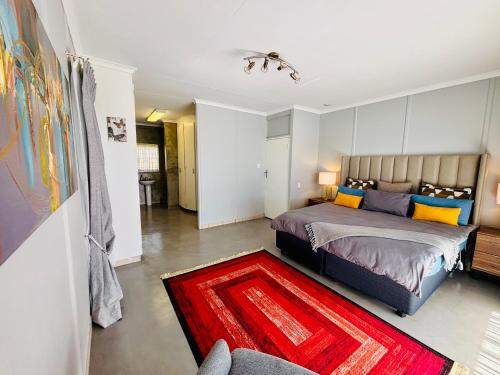 a bedroom with a bed and a red rug at Homestead in Kempton Park