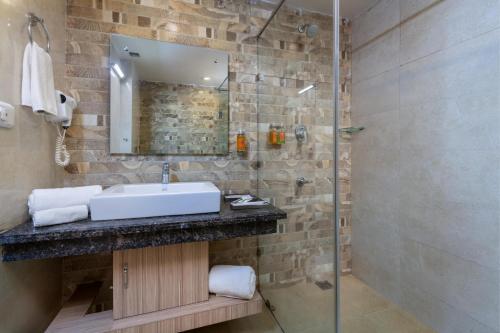 a bathroom with a sink and a glass shower at Zone Connect by The Park Katra in Katra