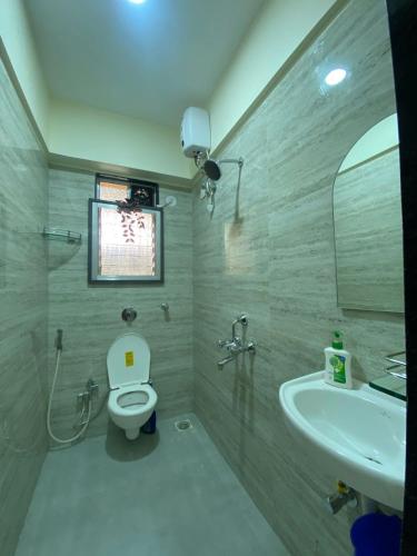 a bathroom with a toilet and a sink at Sheetal Vaibhav 902 in Mumbai
