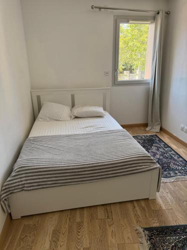 a bed in a bedroom with a window at Résidence inside in Ferney-Voltaire