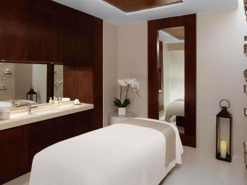 a bedroom with a white bed and a sink at Pullman Dubai Creek City Centre Residences in Dubai