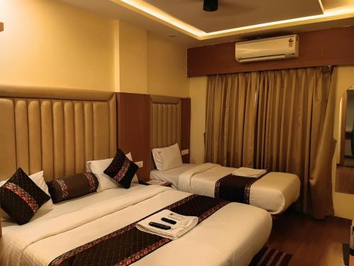 a hotel room with two beds in a room at Hotel Rajwada Nagpur in Nagpur