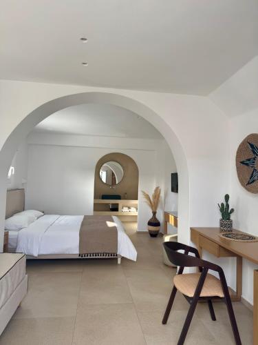 a bedroom with a bed and a desk and a chair at Esperides in Platis Gialos