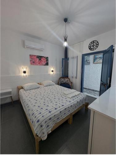 a bedroom with a bed and a clock on the wall at ÇAKIR's HOME OTEL in Çeşme