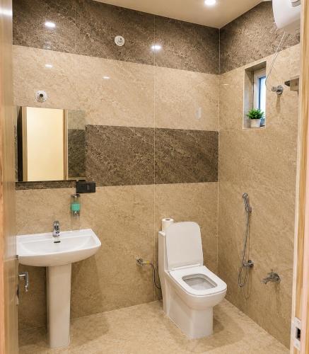 a bathroom with a toilet and a sink at Hotel Pratishtha in Rishīkesh