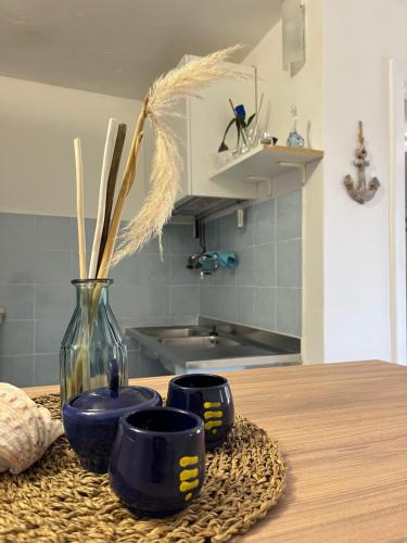 a table with two blue cups and a vase on it at Casa vacanze Alfano in Ascea