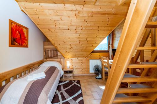 a bedroom with stairs in a log cabin at Salaš Vígľaš in Bojnice