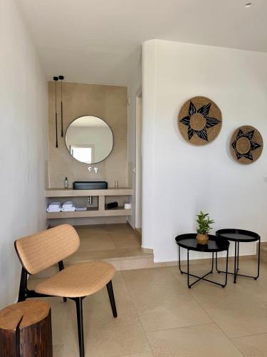 a living room with two chairs and a mirror at Esperides in Platis Gialos