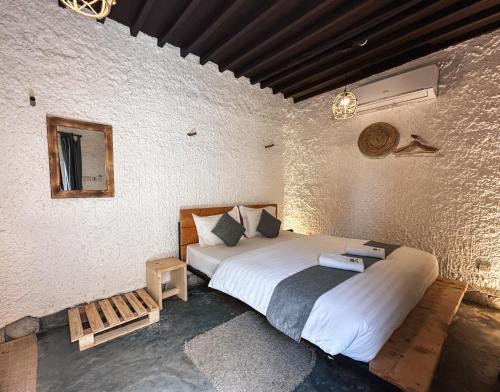a bedroom with a large bed in a room at SAMA Al Khutaim-Heritage Home in Nizwa