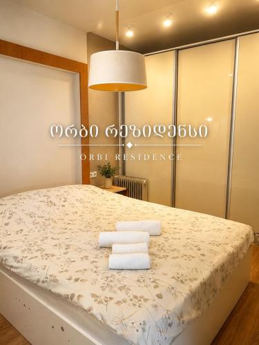 a bedroom with a large bed with towels on it at Orbi Residence in Itʼkhvisi