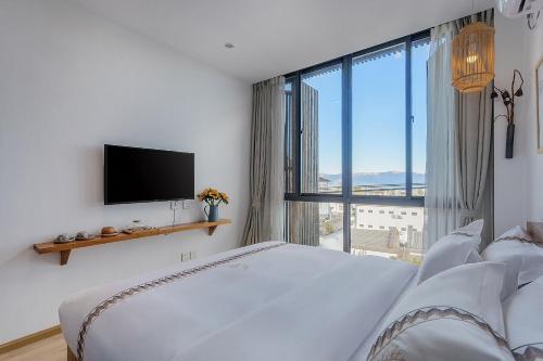 a bedroom with a white bed and a large window at 鹿野山房 DeerHoliday Inn in Dali
