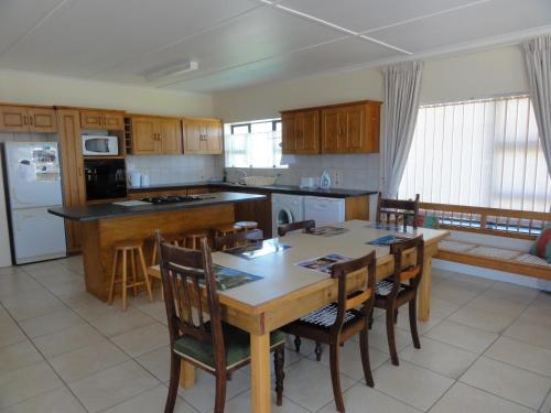 a kitchen with a table and chairs and a dining room at Berg En See in Kleinmond