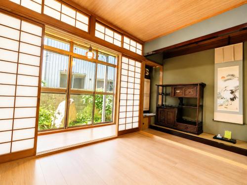 an empty room with a large window and a wooden floor at Joynest TAKAMATSU in Takamatsu