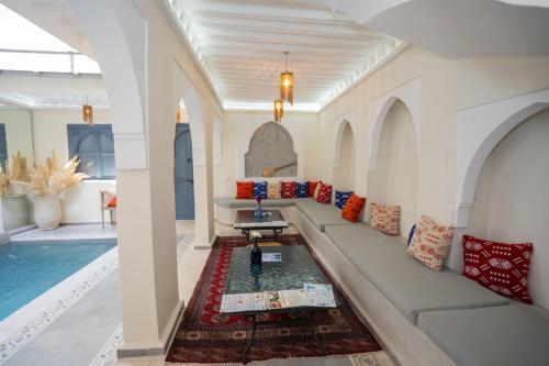 a living room with a couch and a swimming pool at Riad Blue Berry & SPA in Marrakesh