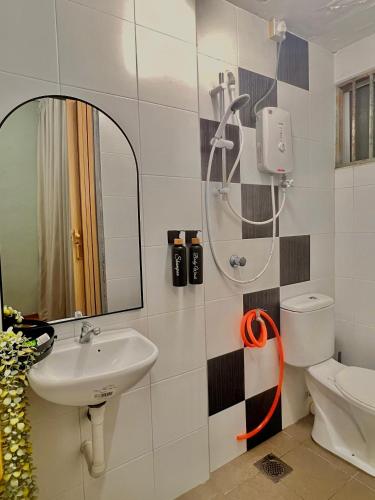 a bathroom with a sink and a mirror and a toilet at LS homestay Ipoh in Chemor