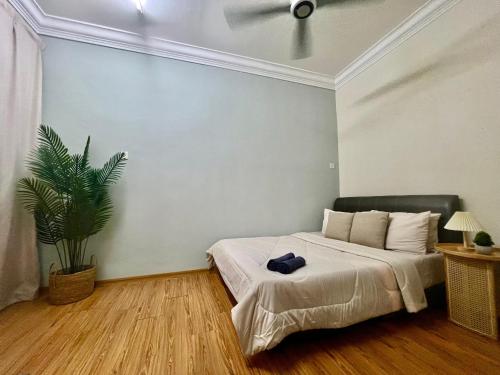 a bedroom with a bed and a plant in it at LS homestay Ipoh in Chemor
