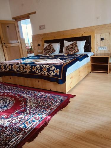 a bedroom with a large bed with a rug at Odbar Guest House Best Guest House at Leh Ladakh in Leh