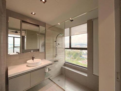 a bathroom with a sink and a glass shower at WGS Suites at KLCC, 300Mbps WiFi in Kuala Lumpur