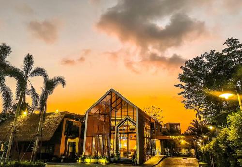 a large glass building with a sunset in the background at K.B. Resort in Ko Chang