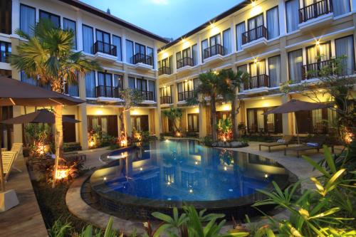 an exterior view of a hotel with a swimming pool at Suris Boutique Hotel in Kuta