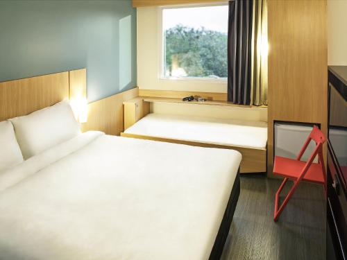 a small room with two beds and a window at ibis Rio de Janeiro Parque Olimpico in Rio de Janeiro
