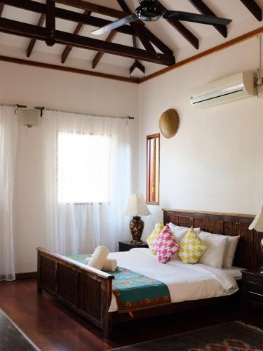 a bedroom with a large bed and a window at Rumah Jah Langkawi in Pantai Cenang
