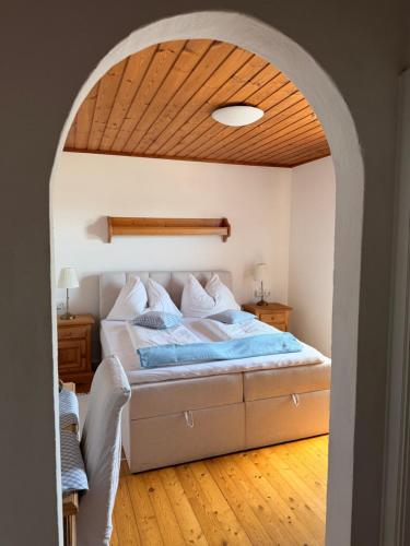 a bedroom with a bed with a wooden ceiling at Gasthof Fersterer in Lamprechtshausen