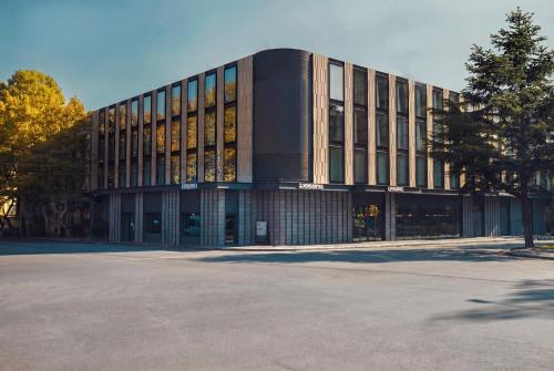 a large building with a parking lot in front of it at Episode Tbilisi in Tbilisi City