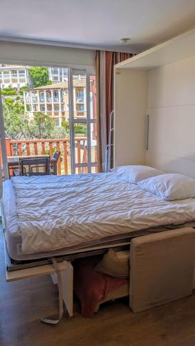 a large bed in a bedroom with a balcony at Studio cabine climatisé vue golf à Cap Estérel in Saint-Raphaël