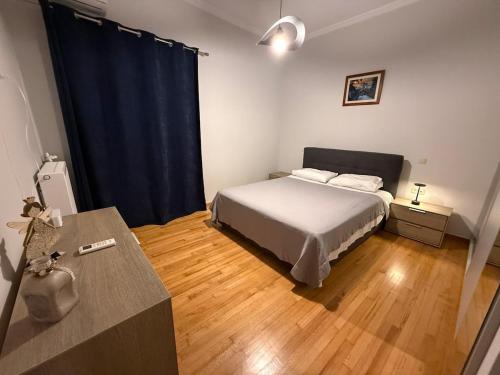a bedroom with a bed and a blue curtain at Skyfall with a large balcony and FREE parking in Central Kiato in Kiaton