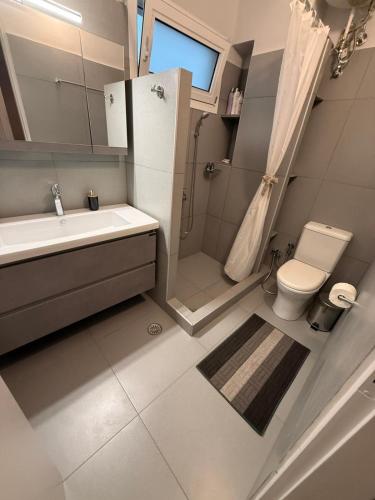a bathroom with a sink and a toilet and a shower at Skyfall with a large balcony and FREE parking in Central Kiato in Kiaton