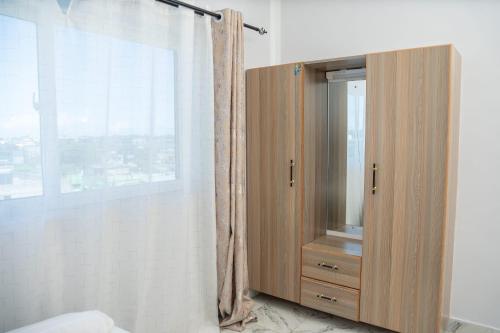 a wooden cabinet in a room with a window at Malindi White in Malindi