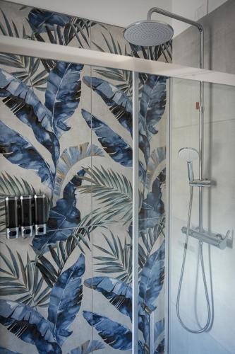 a bathroom with a shower with a mural of leaves at Antares b&b in Cassina deʼ Pecchi