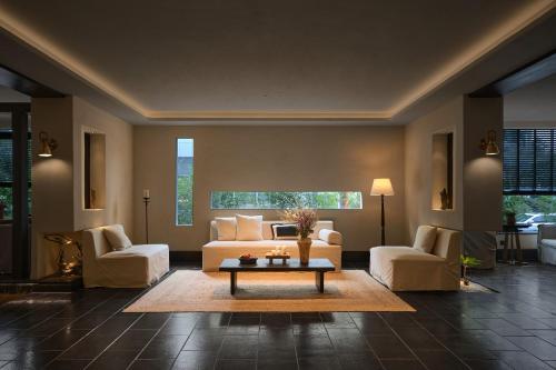 a living room with a couch and two chairs and a table at Chengdu Yunduo Bieyuan 云朵 Hotel in Chengdu