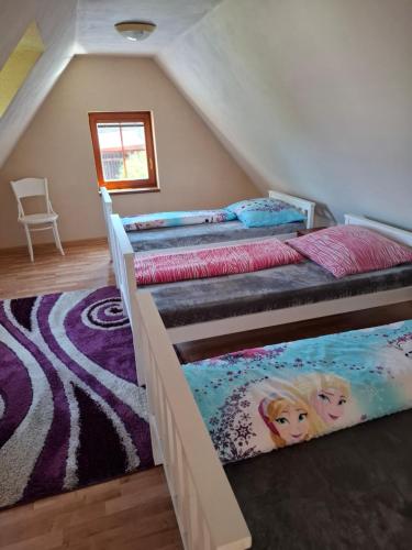 two bunk beds in a room with a attic at Chalupa u Záhradníkov in Trebostovo