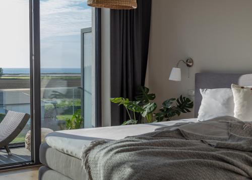 a bedroom with a bed and a large glass window at FerienDüne "Riedensee" in Kühlungsborn