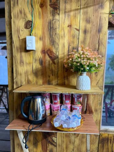 a shelf with a plate of food and a vase at Homestay Vườn Cam in Kon Von Kla