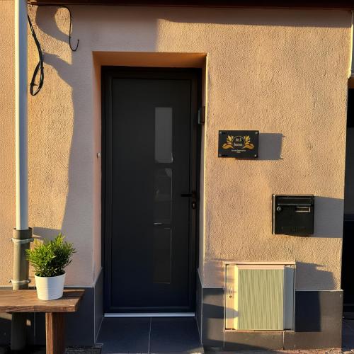 a black door of a building with a wooden bench at Suite Pacifique - Spa privatif avec baignoire in Calais