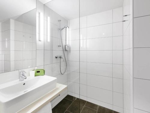 a white bathroom with a sink and a shower at ibis budget Konstanz in Konstanz