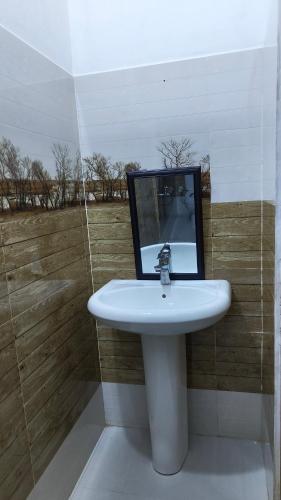 a bathroom with a sink and a mirror on a wall at Jayasiri Riverfront Home in Lansiyawatta