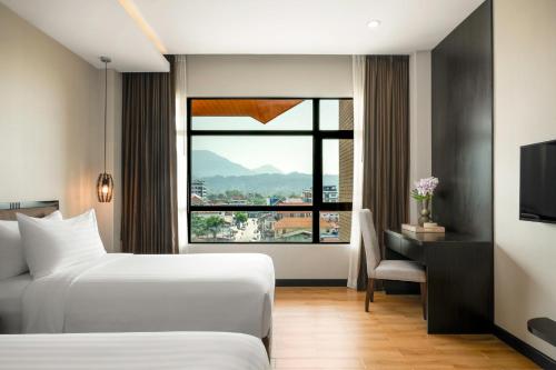 a hotel room with a bed and a window at Amari Vang Vieng in Vang Vieng