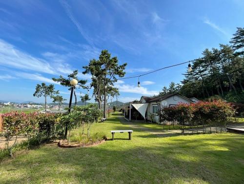 a park with a bench in the middle of a yard at Wando Haegeum Pension in Wando