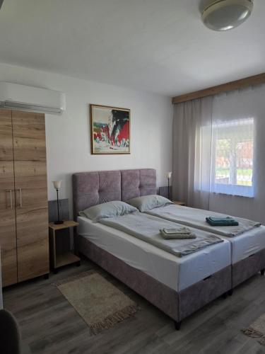 a bedroom with a large bed and a window at Self Check-in Studio apartman Vito in Lipovac