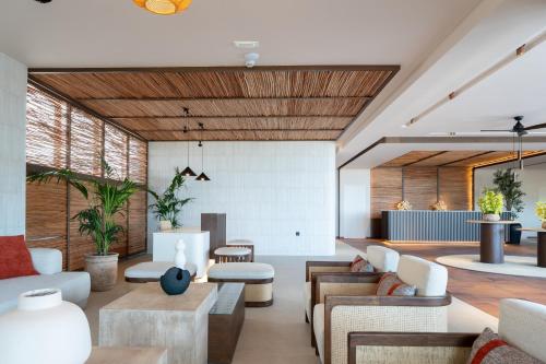 a living room with couches and tables at Kouros Palace Active Lifestyle Hotel in Mastihari