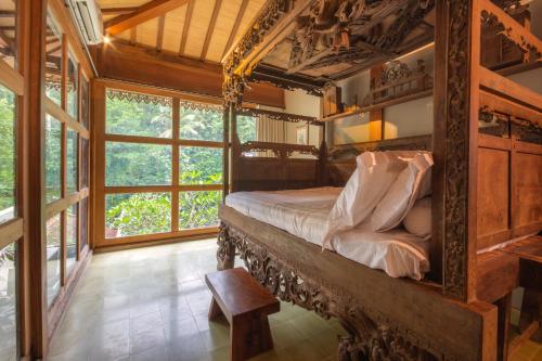 a bedroom with a bed in a room with windows at The Villa Lululu in Tabanan