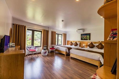 a hotel room with two beds and two chairs at SAPA DEBOUTIQUE Hotel in Sapa